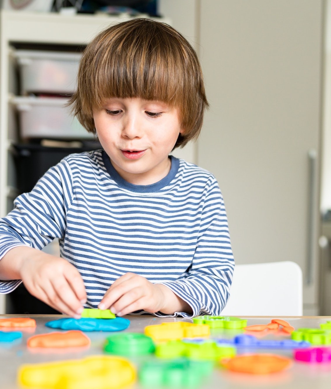 A young boy playing at a craft table in his own home