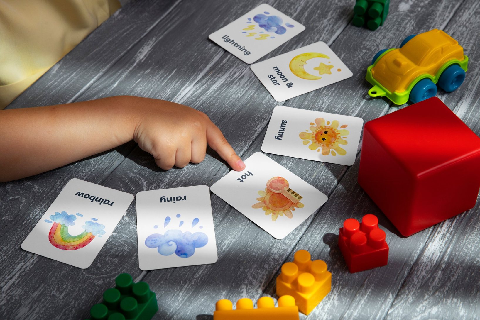 A child pointing at picture cards during a teaching activity at home